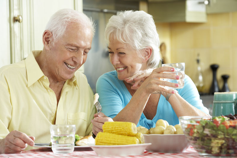 Dental Implant Patients Eating Dinner And Smiling Together