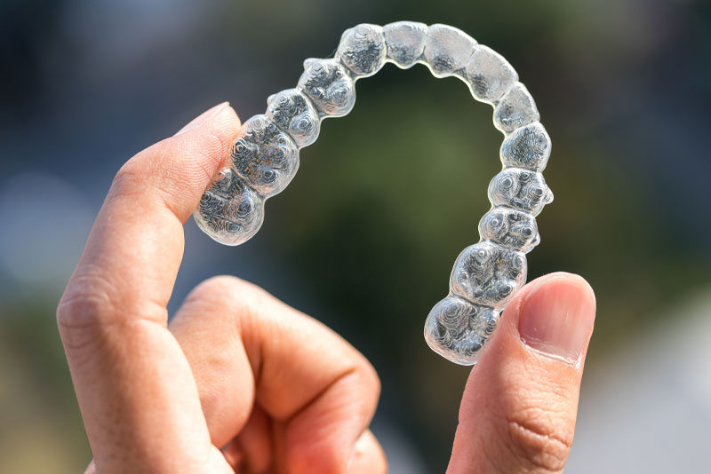 Invisalign Retainers Model Being Held Up