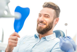 a dental implant patient smiling after cosmetic dentistry