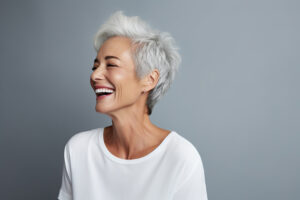 Photo of a older women patient smiling in a gray backdrop