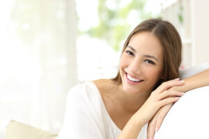 Female dental patient looking with smile in dental clinic, background is dental office, dental technology, bright room.