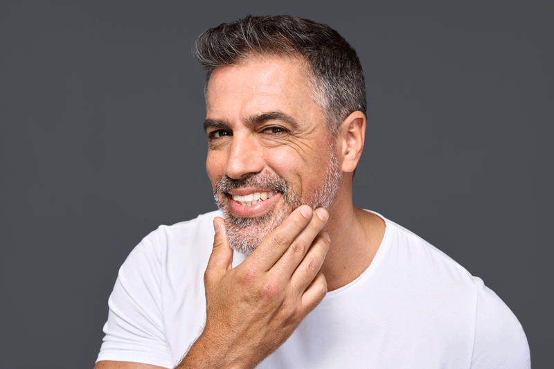 Happy confident handsome mature older man, smiling middle aged male model wearing white t-shirt.