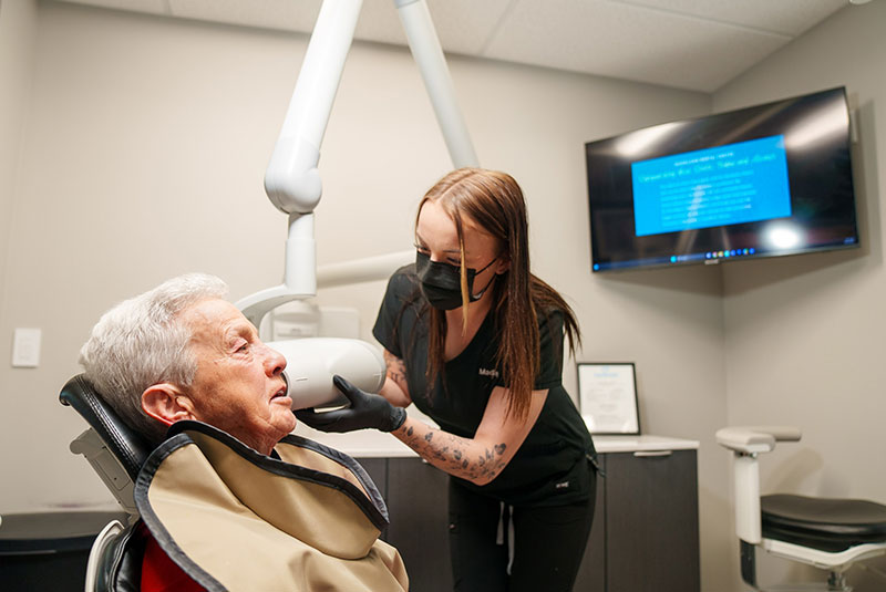 team member taking a x-ray of the patient's teeth
