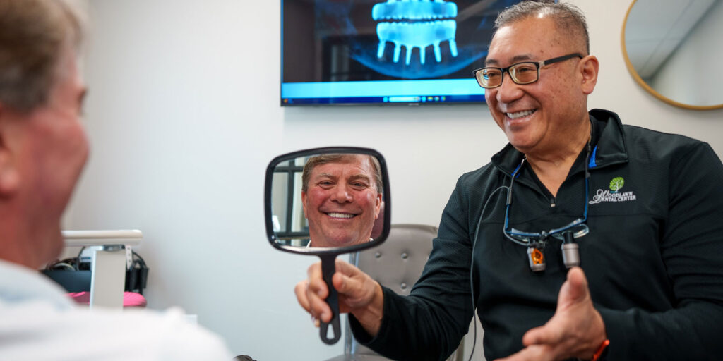 Patient looking into mirror that doctor is holding